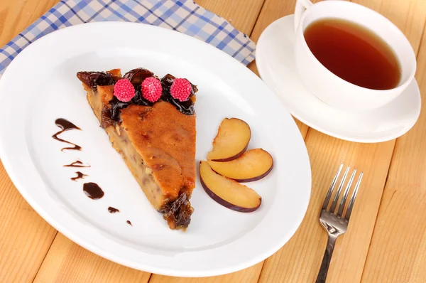 Tasty pie on plate on wooden table — Stock Photo, Image