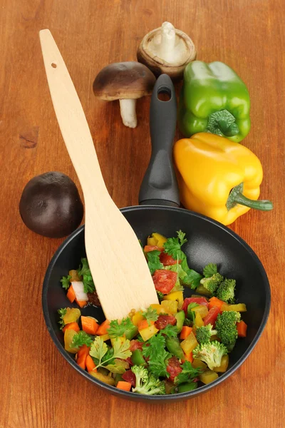 Нарезанные свежие овощи в кастрюле со специями и ингредиентами на деревянном столе — стоковое фото