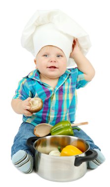 şef şapkasını pan ve sebzeler üzerinde beyaz izole, küçük çocuk