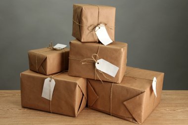kutuları gri arka plan üzerinde ahşap masa hakkında kraft kağıt paketler