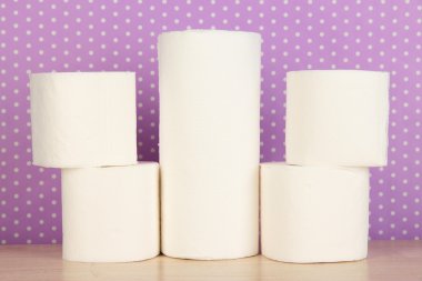 Rolls of toilet paper on purple with dots background