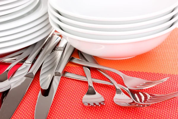 Forchette, coltelli e cucchiai su tappetino rosso primo piano — Foto Stock