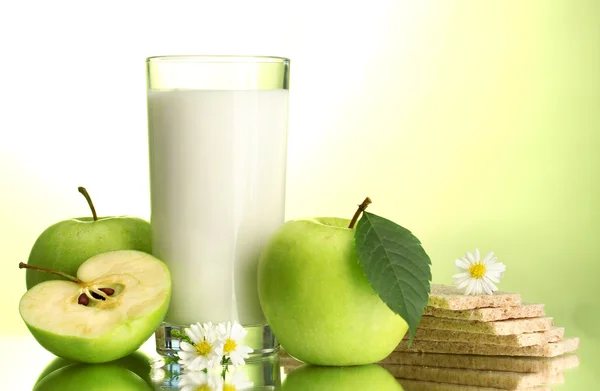 Vaso de kéfir, manzanas y panes fritos, sobre fondo verde — Foto de Stock