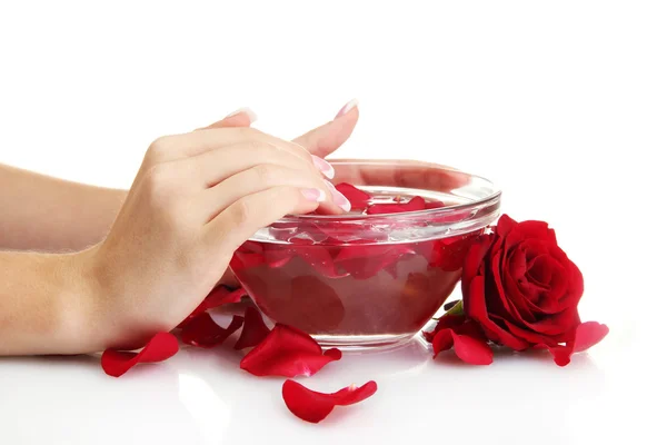 Vrouw handen met glazen kom van water met bloemblaadjes, geïsoleerd op wit — Stockfoto