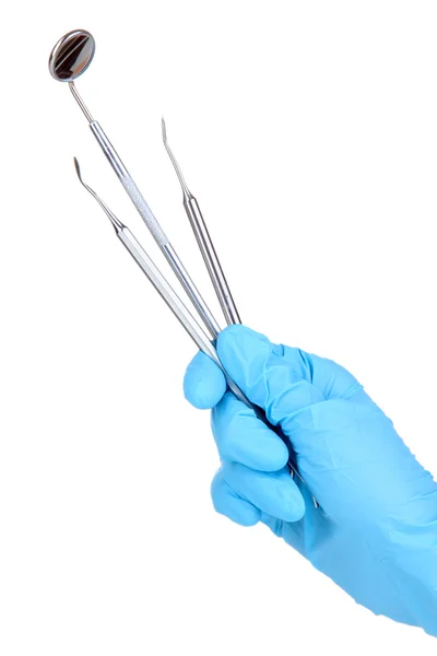 Hand in blauwe handschoen houden tandheelkundige tools op wit wordt geïsoleerd — Stockfoto