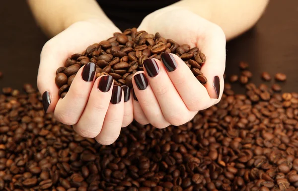 Mãos femininas com grãos de café, close-up — Fotografia de Stock