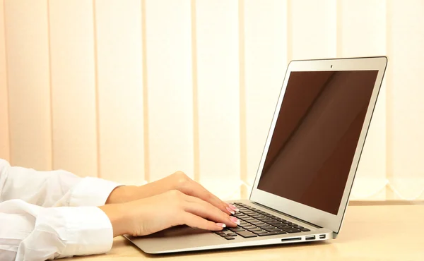 Mãos femininas escrevendo em um laptop branco, close-up — Fotografia de Stock