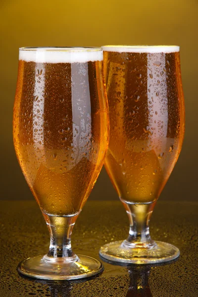 Briller av øl på gul bakgrunn – stockfoto