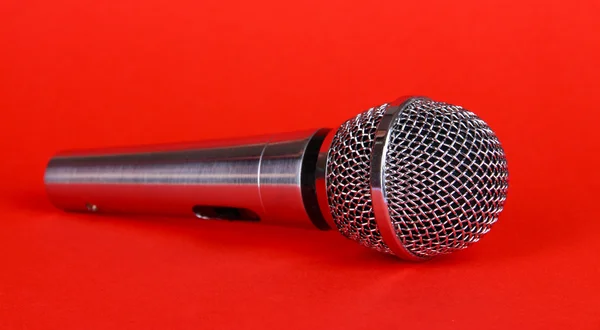 Silbernes Mikrofon auf rotem Hintergrund — Stockfoto
