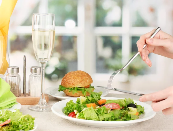 Weibliche Hand mit Abendessen auf hellem Hintergrund — Stockfoto