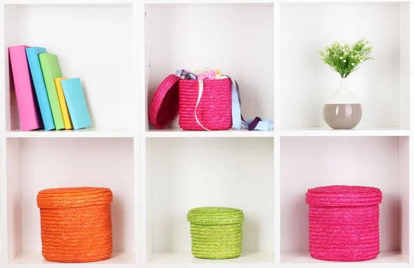 Caixas de vime de cor nas prateleiras do armário — Fotografia de Stock