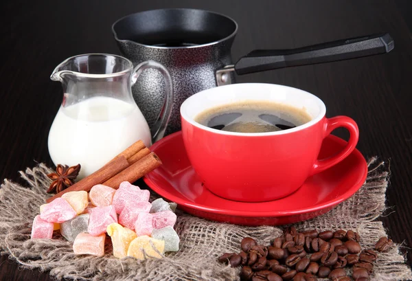 Red cup of coffee with rahat delight, milk and coffee pot on wooden table — Stock Photo, Image