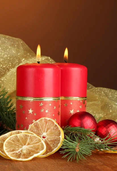 Due candele e decorazioni natalizie, su sfondo di legno — Foto Stock
