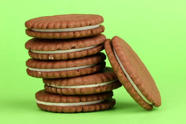 Yeşil zemin üzerine krem tabakası ile çikolatalı kurabiye — Stok fotoğraf