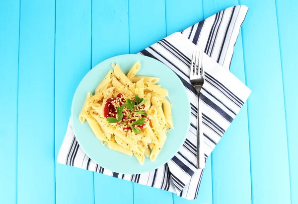 Rigatoni pasta dish with tomato sauce on blue wooden table — Stock Photo, Image