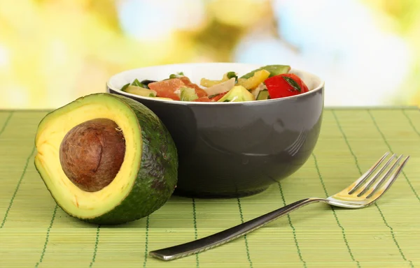 Sabrosa ensalada de aguacate en tazón sobre mesa de madera sobre fondo natural —  Fotos de Stock