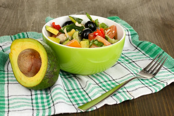 Sabrosa ensalada de aguacate en tazón sobre mesa de madera de cerca —  Fotos de Stock