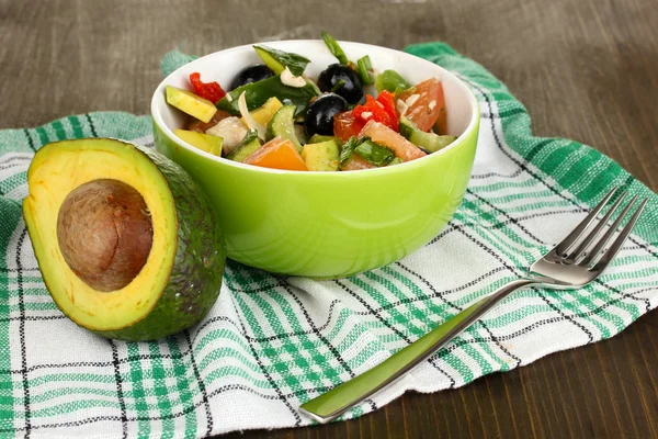 Tasty avocado salad in bowl on wooden table close-up — Stock Photo, Image