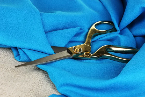 Metal scissors on blue fabric — Stock Photo, Image