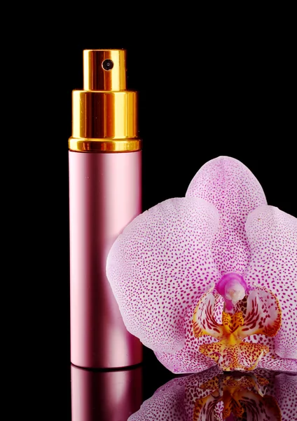 Kadın parfümü güzel şişe ve siyah arka plan üzerinde orkide çiçek — Stok fotoğraf