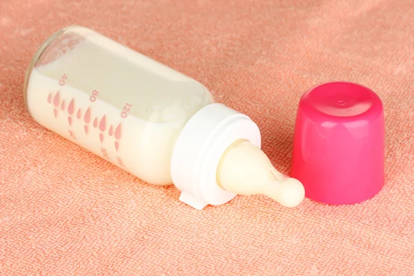Babyfles melk op roze handdoek — Stockfoto