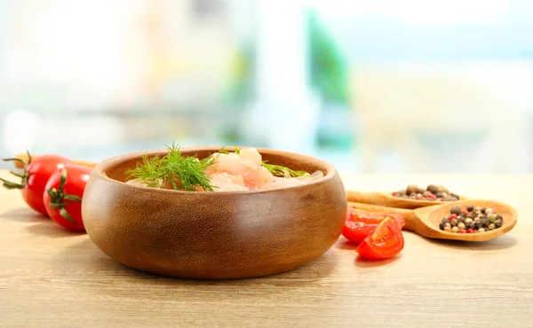 Raw chicken meat in bowl, on wooden table — Stock Photo, Image