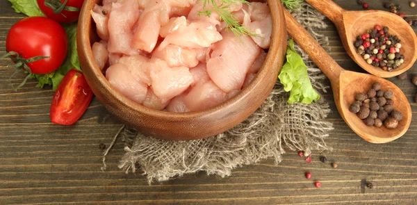 Raw chicken meat in bowl, on wooden background — Stock Photo, Image