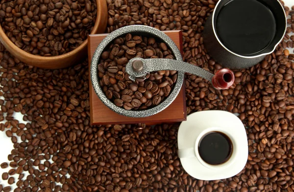 Kaffeemühle, Türke und Tasse Kaffee auf Bohnen Hintergrund — Stockfoto
