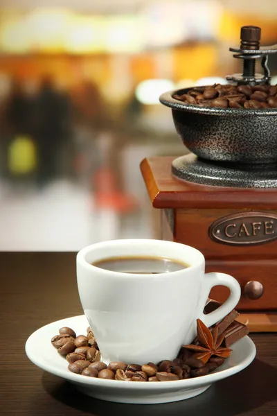 Xícara de café, moedor e grãos de café no café — Fotografia de Stock