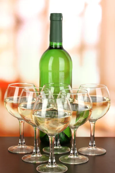 Bílé víno ve sklenici a láhev na pozadí místnosti — Stock fotografie