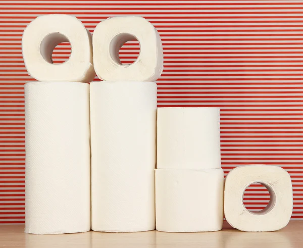 Rolls of toilet paper on striped red background — Stock Photo, Image