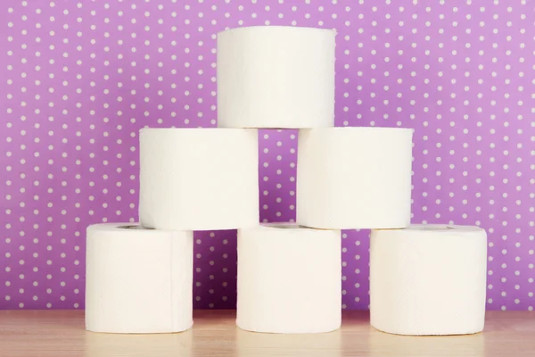 Rolls of toilet paper on purple with dots background — Stock Photo, Image