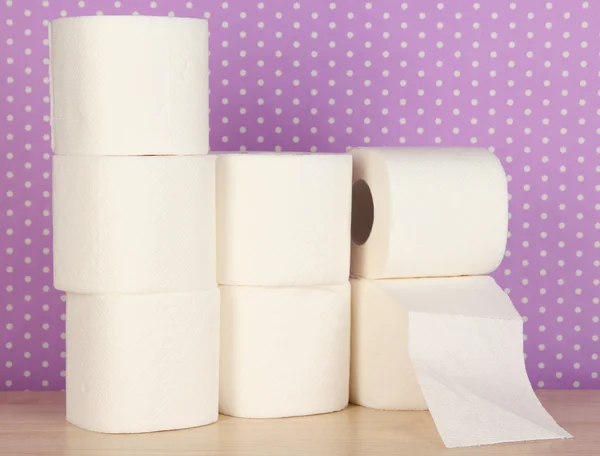 Rolos de papel higiênico em roxo com fundo de pontos — Fotografia de Stock