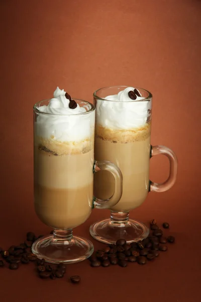 Doftande kaffe latte i glas koppar, på brun bakgrund — Stockfoto