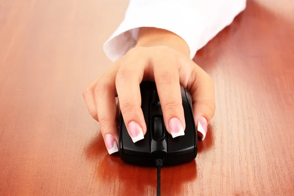 Las manos de la mujer empujando las teclas del ratón de la PC, en la mesa de madera de cerca — Foto de Stock