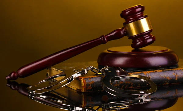 Gavel, handcuffs and book on law on yellow background — Stock Photo, Image