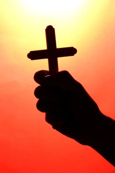 Man hand with crucifix, on red background — Stock Photo, Image