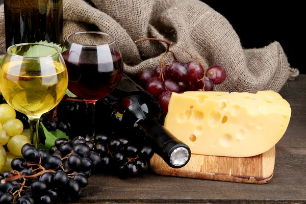 Flaschen und Gläser mit Wein, Käse und Trauben auf grauem Hintergrund — Stockfoto