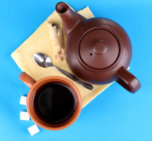 Top view of cup of tea and teapot on blue tablecloths — Stock Photo, Image