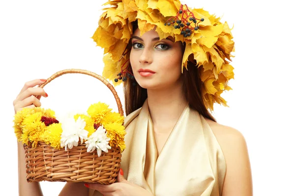Όμορφη νεαρή γυναίκα με το κίτρινο στεφάνι φθινόπωρο και καλάθι με λουλούδια, που απομονώνονται σε λευκό — Φωτογραφία Αρχείου