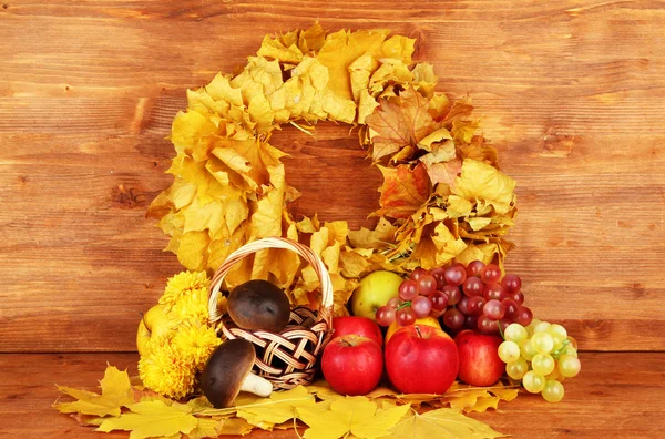Composición otoñal con hojas amarillas, manzanas y setas sobre fondo de madera — Foto de Stock