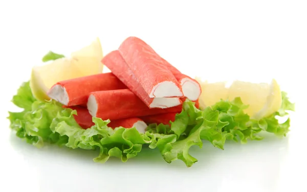 Palitos de cangrejo sobre hojas de lechuga con limón, aislados sobre blanco —  Fotos de Stock