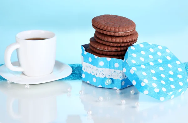 Kremsi katman ve mavi zemin üzerine kahve fincan çikolata kurabiye — Stok fotoğraf