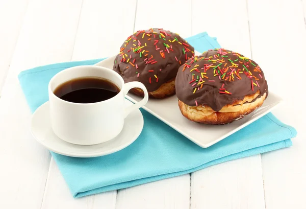 Tasty donuts on color plate on light wooden background — Stock Photo, Image