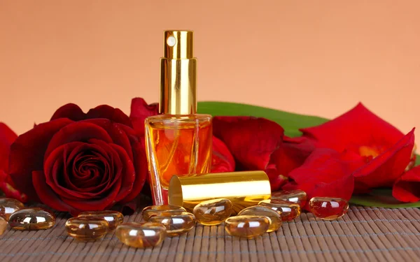 Women's perfume in beautiful bottle with rose on brown background — Stock Photo, Image