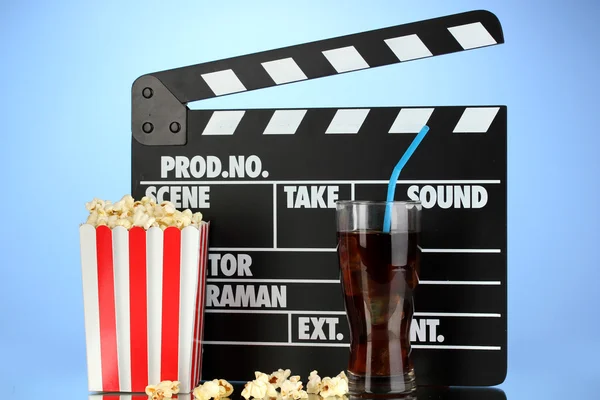 Film clapperboard, cola i popcorn na niebieskim tle — Zdjęcie stockowe