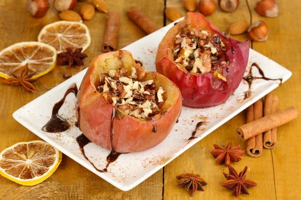 Manzanas al horno en plato sobre mesa de madera —  Fotos de Stock