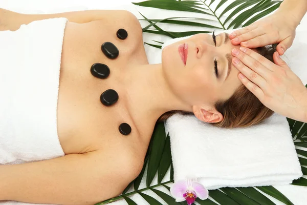 Retrato de mujer hermosa con piedras de spa tomando masaje en la cabeza — Foto de Stock