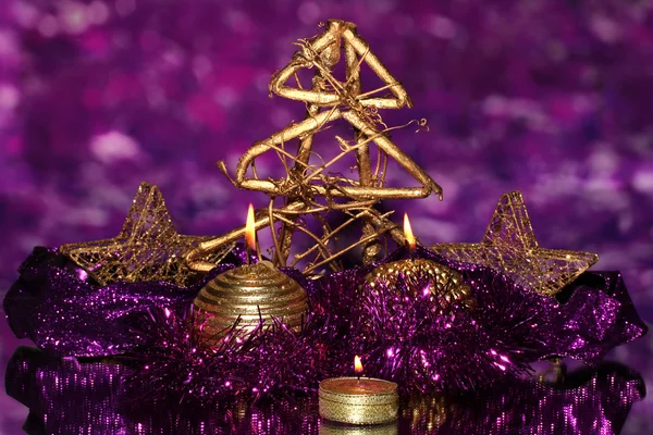 Composição de Natal com velas e decorações em roxo e ouro cores sobre fundo brilhante — Fotografia de Stock