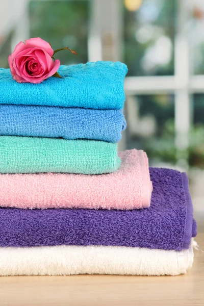 Pilha de toalhas com flor perfumada no fundo da janela — Fotografia de Stock